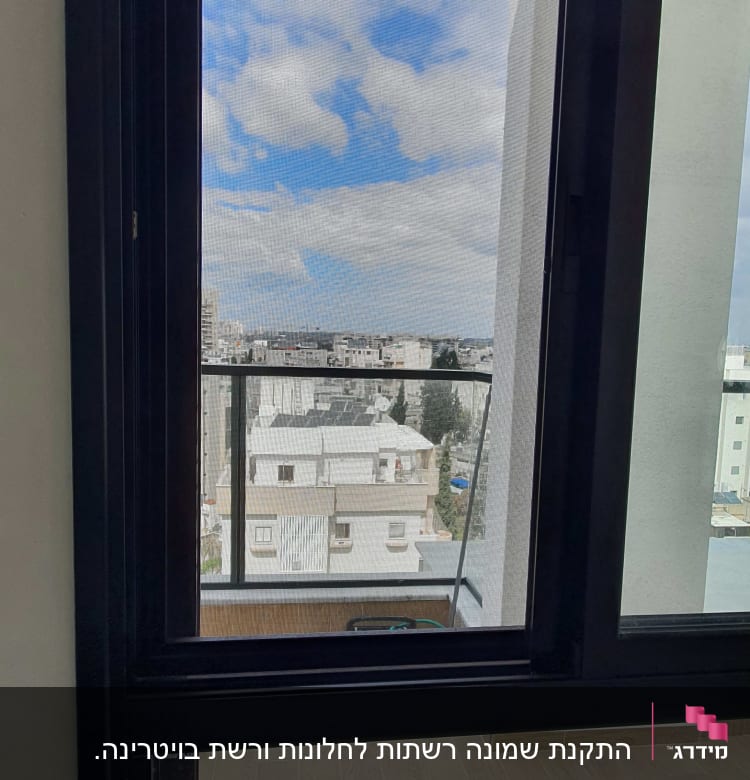 חלון אלומיניום עם מסגרת כהה ונוף עירוני